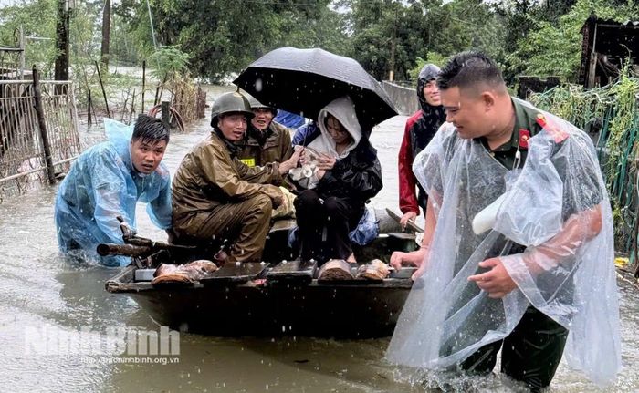 Cán bộ, chiến sĩ Công an tỉnh Ninh Bình giúp đỡ người dân di dời đến nơi an toàn. Nguồn: Công an tỉnh