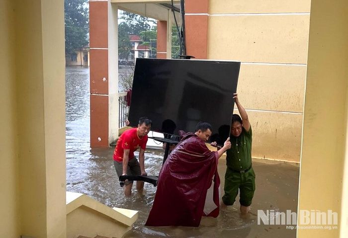 Lực lượng tại chỗ xã Tân Thanh hỗ trợ trường THCS Tân Thanh kê cao, di chuyển tài sản, trang thiết bị đến vị trí an toàn trước nguy cơ ngập lụt cao. Ảnh: Trần Giang