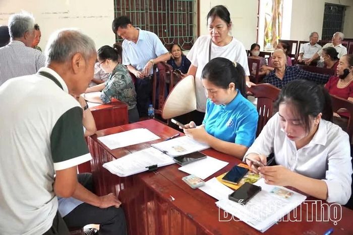 Cán bộ MTTQ và các tổ chức chính trị - xã hội hướng dẫn người dân cài đặt, sử dụng ứng dụng thanh toán không dùng tiền mặt.