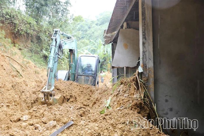 Lực lượng chức năng huy động máy xúc để cào bới đất, phòng ngừa nguy cơ sạt lở tiếp tục diễn ra.