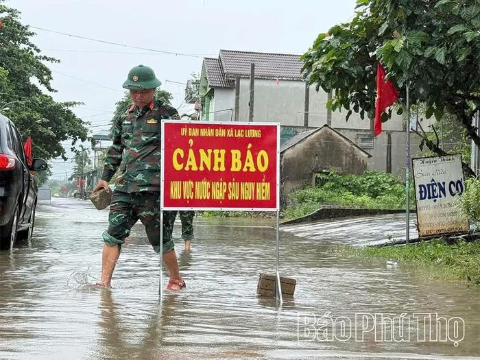 Lực lượng chức năng xã Lạc Lương cắm biển cảnh báo khu vực nước sâu nguy hiểm, đồng thời phân công lực lượng hướng dẫn người dân lưu thông an toàn trên những tuyến đường bị ngập úng.