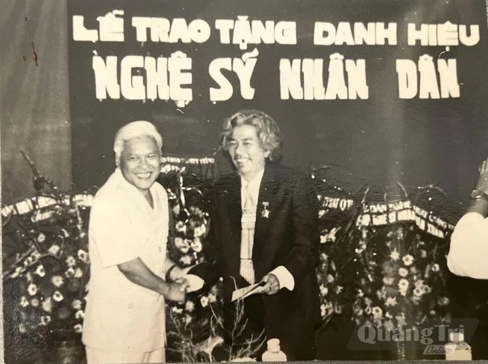 Đạo diễn Xuân Đàm ( bên phải) đón nhận danh hiệu Nghệ sĩ Nhân dân - Ảnh: Đ.T.T