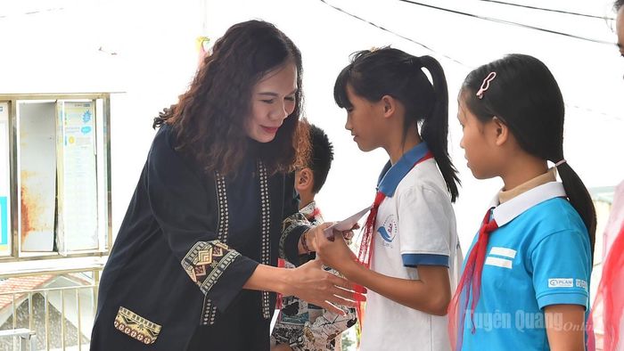 Đồng chí Ngô Thị Thu Hà, Phó Giám đốc Báo và phát thanh, truyền hình Tuyên Quang trao quà cho học sinh.