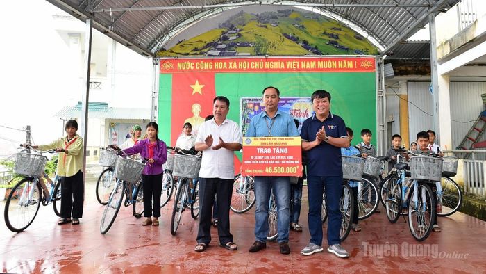 Đồng chí Mai Đức Thông, Giám đốc Báo và phát thanh, truyền hình Tuyên Quang trao xe đạp cho các em học sinh.