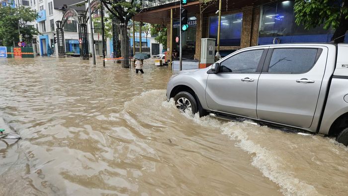 Tuyến đường dẫn đến Trường Tiểu học Vinschool Smart City ngập sâu sau mưa lớn, khiến phương tiện di chuyển khó khăn.