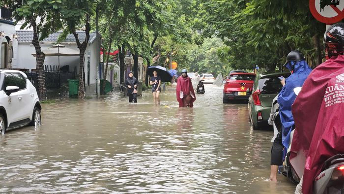 Người dân phải ngồi chờ trên xe do không thể di chuyển qua khu vực ngập sâu.