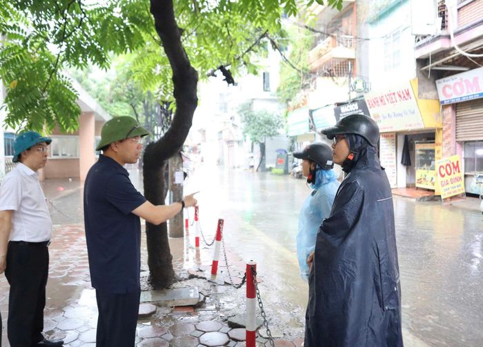 Lãnh đạo phường Từ Liêm kiểm tra, chỉ đạo lực lượng chức năng khắc phục ngập úng. (Ảnh: PV).