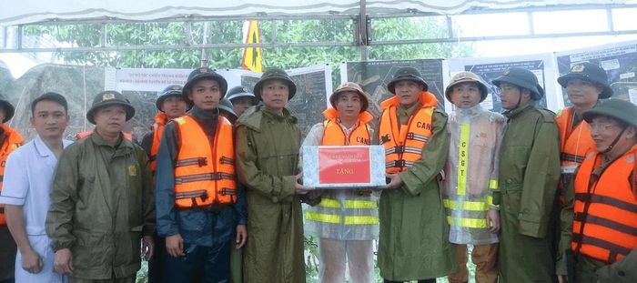 Chủ tịch UBND tỉnh Tô Anh Dũng trao tặng quà động viên lực lượng làm nhiệm vụ ứng phó với mưa lũ. Ảnh: Phong Sắc