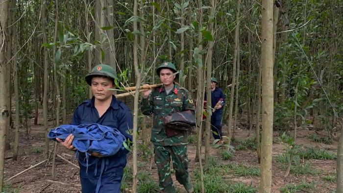 Lực lượng chức năng di chuyển hài cốt liệt sĩ vừa tìm thấy về nơi bảo quản hương khói. Ảnh: Võ Linh