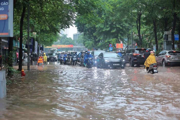 Đường phố ngập khiến người dân đi làm chật vật hơn (Ảnh Lê Khánh).
