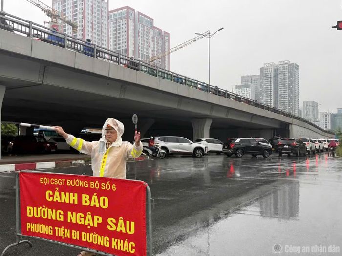 Đội CSGT số 6 (Phòng CSGT Công an Hà Nội) đặt cảnh báo và phân luồng phương tiện di chuyển tại đường Phạm Hùng.