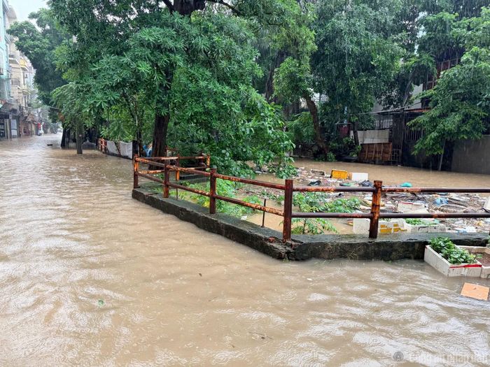 Người dân di chuyển qua tuyến đường 70 bị ngập sâu. Nhiều người điều khiển xe máy phải giảm tốc độ, dò đường qua những đoạn nước sâu.