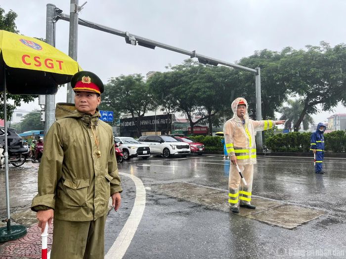 Cán bộ Đội CSGT số 5 phối hợp cùng Công an phường điều tiết, phân luồng giao thông di chuyển tại khu vực cầu Chương Dương trong mưa.
