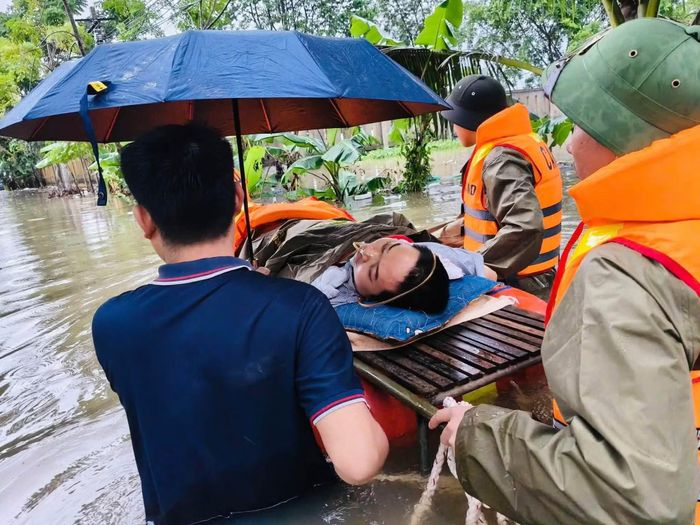 Các cán bộ, chiến sĩ phối hợp với gia đình đưa người bệnh lên xuồng, vượt qua khu vực ngập sâu để nhanh chóng đưa đến Trạm Y tế xã Nông Cống.