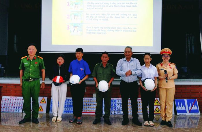 Ông Phùng Văn Huy, Bí thư Đảng ủy, và đại diện Công an xã Trà My trao quà tặng người dân, học sinh.