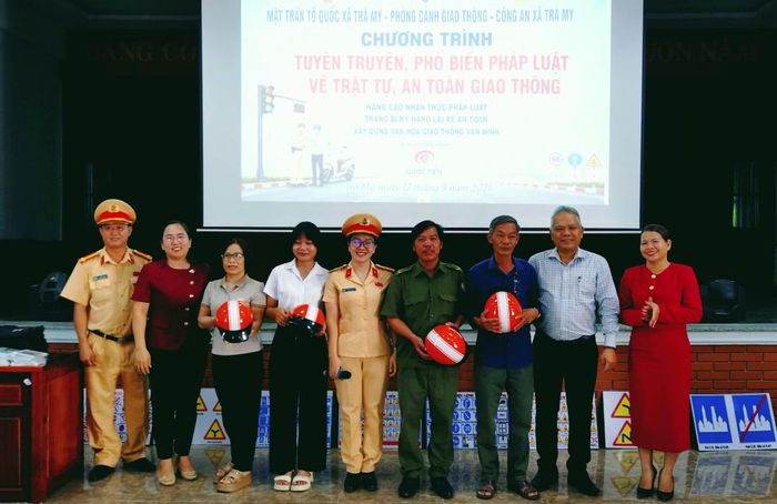 Lãnh đạo xã Trà My và Đội CSGT số 2 trao quà tặng người dân, học sinh có câu trả lời đúng về kiến thức an toàn giao thông.