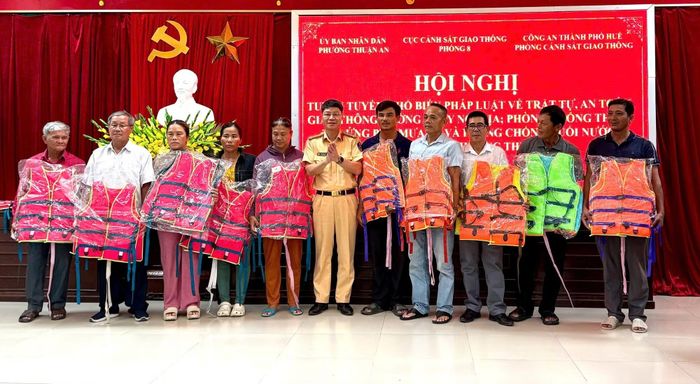 Lãnh đạo Phòng Hướng dẫn tuần tra, kiểm soát và đấu tranh PCTP trên đường thủy nội địa, Cục CSGT tặng áo phao cho ngư dân ở phường Thuận An.
