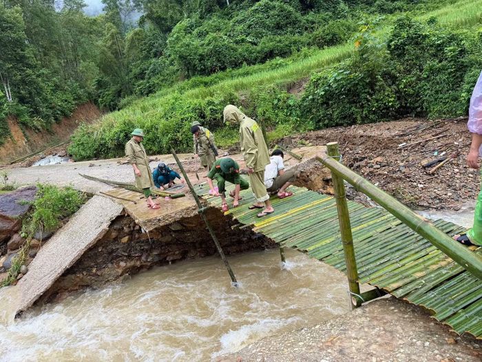 Công an xã Quan Sơn bắc cầu tạm sau khi mố cầu bị nước lũ cuốn trôi.