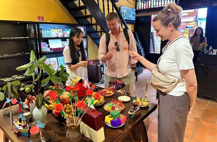 Du khách nước ngoài thích thú với các đồ chơi trung thu truyền thống tại Ngôi nhà Di sản.