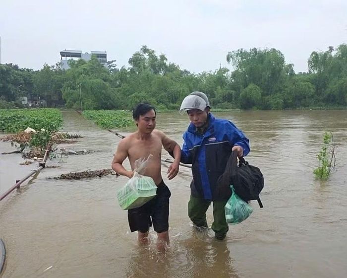 Công an xã Quảng Bị giúp dân chuyển tài sản khỏi nơi ngập úng