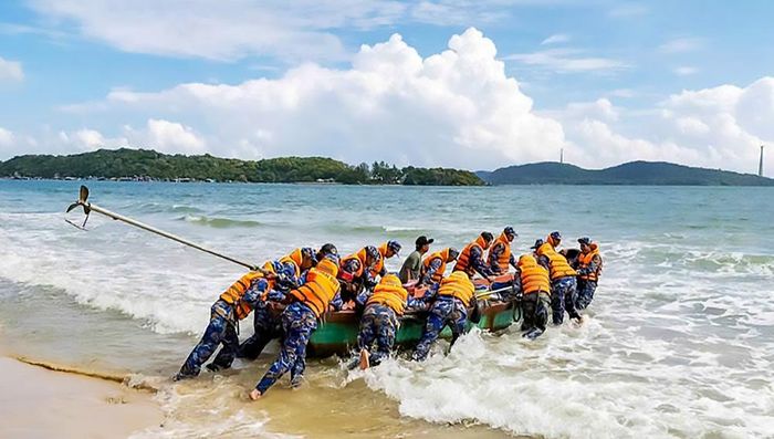 Cán bộ, chiến sĩ Tiểu đoàn 563 hỗ trợ đưa ghe ngư dân ra khỏi nơi mắc cạn.  Ảnh: VĂN ĐỊNH 