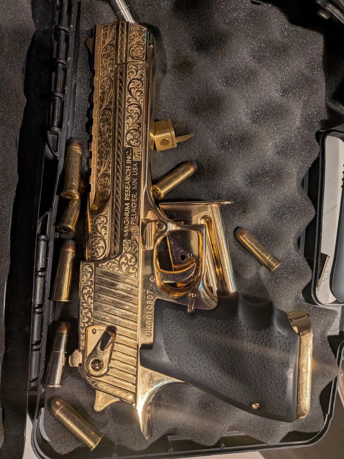 Khẩu súng ngắn Desert Eagle cỡ nòng .50 được mạ vàng, đặt cùng đạn dược trên bàn bếp.