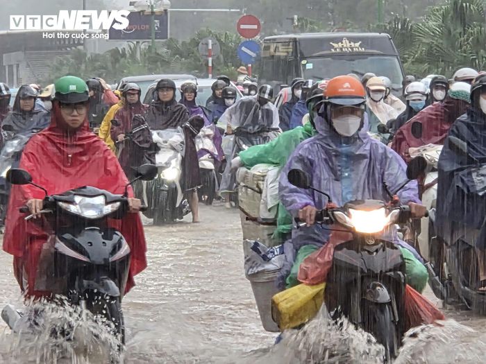 Ô tô, xe máy vất vả đi qua tuyến đường ngập dưới cơn mưa nặng hạt. (Ảnh: Đắc Huy)