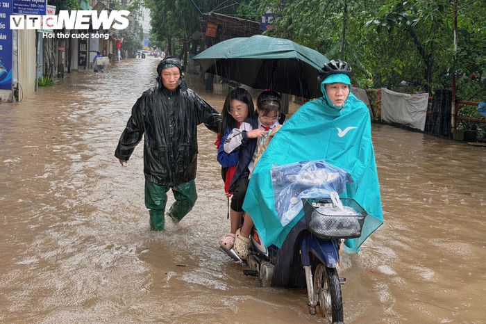 Phụ huynh dắt xe chở con đến trường. (Ảnh: Minh Đức)