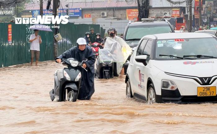 Người dân chật vật đi qua các điểm ngập