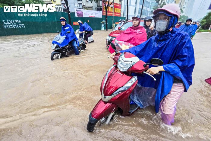 Khoảng 7h cùng ngày, lượng phương tiện đổ về khu vực này tăng nhanh. Tuy nhiên, một đoạn đường dài vẫn ngập sâu gần đầu gối, khiến nhiều xe máy chết máy khi vừa đi vào vùng nước ngập.