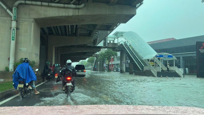 Người dân phải di chuyển trên nhiều tuyến đường Hà Nội bị ngập.