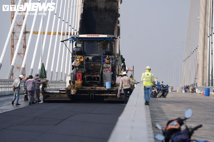 Những mét bê tông nhựa đầu tiên được triển khai trên mặt cầu, đánh dấu bước chuyển mới của công trình sau thời gian thi công.