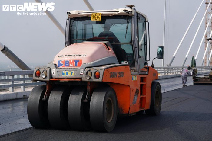 Các kỹ sư kỹ thuật thường xuyên kiểm tra từng đoạn mặt đường nhằm bảo đảm lớp bê tông nhựa được rải theo yêu cầu. Mỗi mét mặt cầu hoàn thiện giúp công trình tiến thêm một bước đến giai đoạn hoàn thành.
