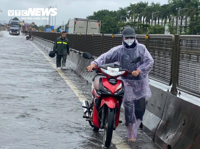 Lực lượng chức năng hướng dẫn ô tô dưới 9 chỗ quay đầu, lựa chọn tuyến đường khác để tránh nguy cơ chết máy. Một số người đi xe máy chọn phương án dắt bộ để đi qua đoạn đường bị ngập thay vì đi vòng.