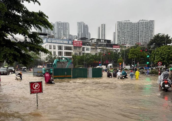 Nước ngập sâu khiến người dân đi lại khó khăn, nhiều phương tiện bị chết máy. Ảnh: AK
