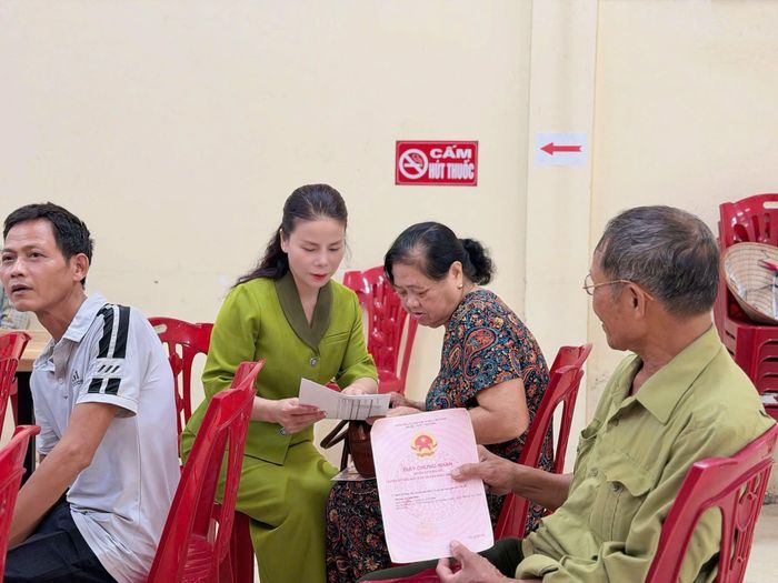 Người dân được Tổ công tác hướng dẫn các thủ tục cần thiết trước khi nhận tiền bồi thường. Ảnh PV