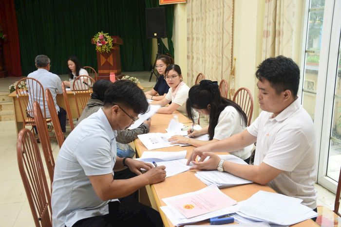 Các hộ dân ký bàn giao mặt bằng và nhận tiền đền bù với cơ quan chức năng xã Ứng Hòa. Ảnh: Phùng Lương