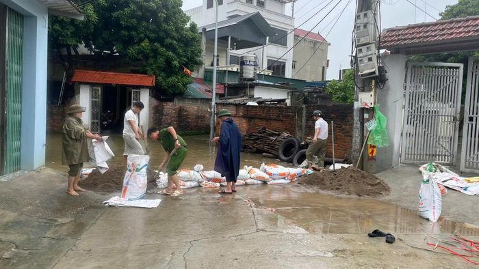 Nhân dân trên địa bàn đắp bao cát ngăn nước tràn vào nhà dân. Ảnh: N.M