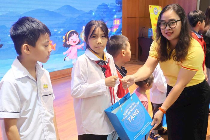 Đại diện Quỹ Thiện Tâm trao hỗ trợ và quà cho trẻ em. Ảnh: Phạm Ban