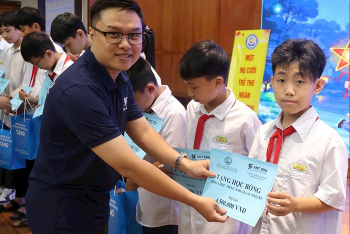 Đại diện Công ty Cổ phần Giáo dục và đào tạo Ant Edu trao học bổng cho trẻ em. Ảnh: Phạm Ban