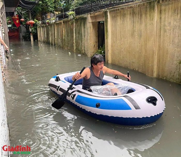 Người dân di chuyển bằng thuyền hơi qua khu vực ngập sâu.