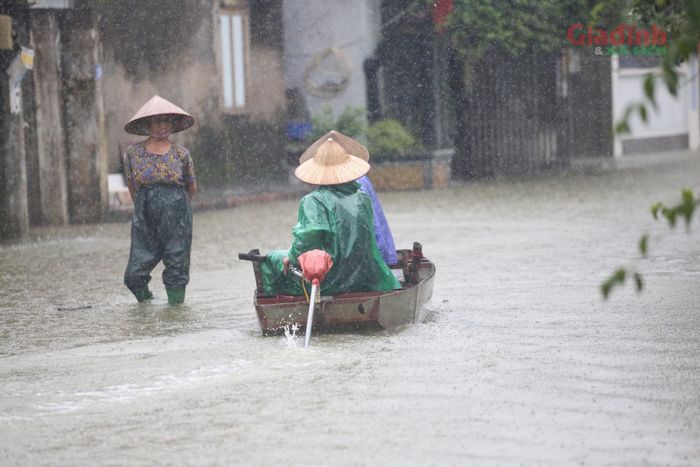 Mặt đường làng thường ngày giờ biến thành dòng nước đục ngầu khiến người dân phải dùng thuyền nhỏ để đi lại.