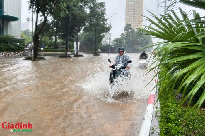 Hàng loạt xe máy, xe ga cố gắng đi đoạn đường bị ngập sâu đến nửa bánh, nhiều phương tiện bị chết máy giữa đường khiến người dân phải vất vả dắt bộ.