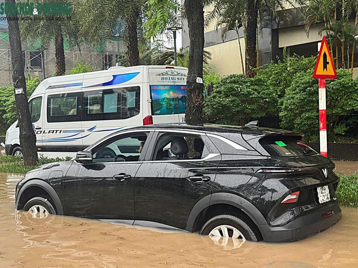 Một ô tô bị nước dềnh, trong khi kính cửa xe vẫn chưa được kéo lên.