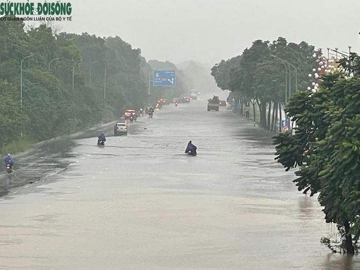 Trên đường gom Đại lộ Thăng Long theo hướng vào nội đô cũng xuất hiện tình trạng ngập, ảnh hưởng đến việc lưu thông của các phương tiện. Ảnh: Phúc Đức