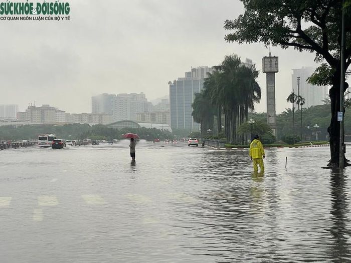 Trước sân vận động Mỹ Đình, một số khu vực xuất hiện nước ngập cục bộ, lực lượng chức năng đã có mặt để xử lý tiêu thoát nước, phân luồng giao thông. Ảnh: Phúc Đức
