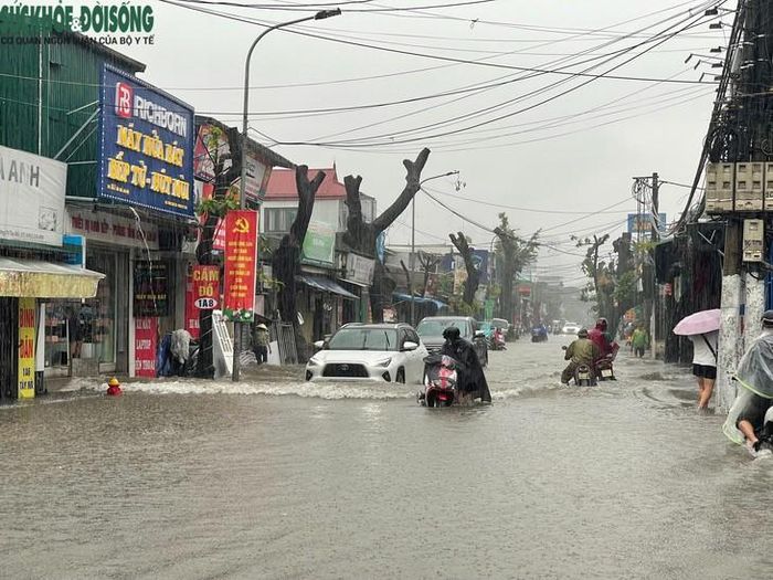 Tại đường Tây Mỗ, nước ngập nhưng vẫn di chuyển được, xe máy, ô tô và người đi bộ gặp khó khăn. Ảnh: Phúc Đức