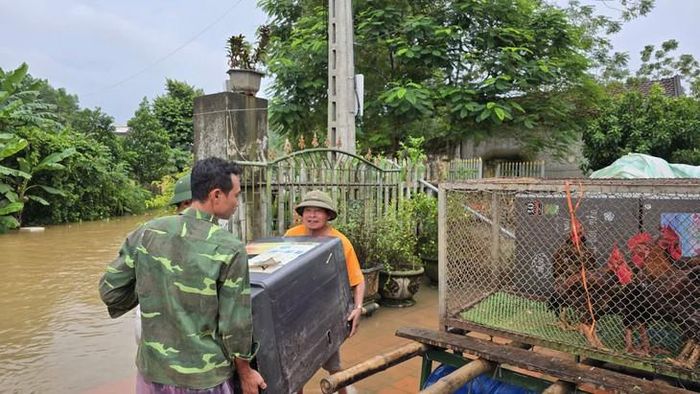 Di dời đồ đạc khi nước sông Bưởi dâng cao. Ảnh: CTV.