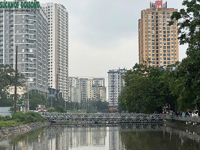 Tại sông Lừ, mực nước dâng sát mép một cây cầu tạm.