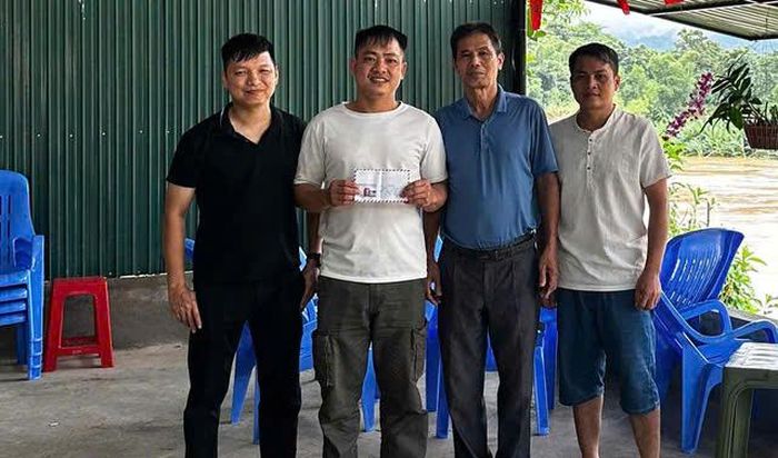 Đại diện Ban quản lý bản Ban thăm hỏi, động viên anh Cao sau khi cứu người giữa dòng lũ. Ảnh: Nhân vật cung cấp